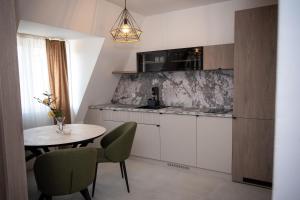 a kitchen with a table and a small table and chairs at I&I Apartments Lux in Kragujevac