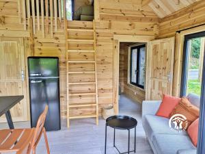 a living room with a couch and a table at Chalet 25 Le Vicoin, Camping de Coupeau, 4 personnes in Saint-Berthevin