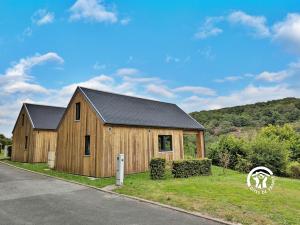 a wooden house on the side of a road at Chalet 25 Le Vicoin, Camping de Coupeau, 4 personnes in Saint-Berthevin