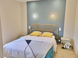 ein Schlafzimmer mit einem Bett mit zwei gelben Kissen in der Unterkunft Gîte la Maillardière, 2 personnes in Crennes-sur-Fraubée