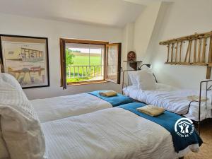 Dos camas en una habitación con ventana. en Gîte Lign' Du Bois, 7 personnes, en Lesbois
