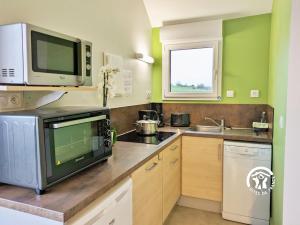 a kitchen with a microwave and a stove top oven at Chalet l'Anguillle in Villiers-Charlemagne