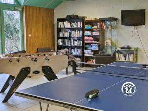 a ping pong table in a room with a book shelf at Chalet l'Anguillle in Villiers-Charlemagne +27 photos