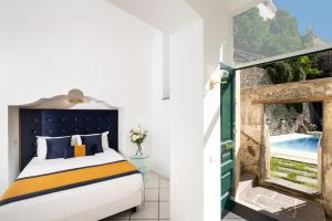 a bedroom with a bed and a window with a pool at Amalfi Relais in Amalfi +84 photos