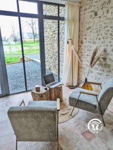 a living room with a couch and a laptop on a table at Gîte Les Haies de Tresmes, jusqu'à 6 personnes in Gesvres