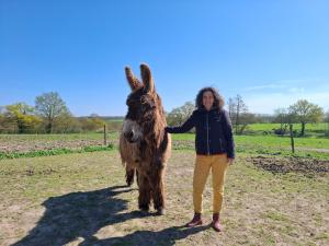 a woman is standing next to a brown donkey at Chez Valentin, jusqu'à 9 personnes in Saint-Denis-dʼAnjou
