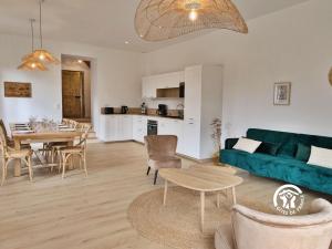 Una sala de estar con un sofá azul y una mesa. en Chez Valentin, jusqu'à 9 personnes, en Saint-Denis-dʼAnjou