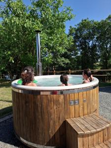 two girls in a hot tub with a bench at Chez Valentin, jusqu'à 9 personnes in Saint-Denis-dʼAnjou