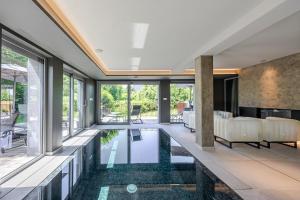 an infinity pool in a house with a living room at La Loge aux Loups, à 100 m du lac, piscine intérieure, sauna, cheminée, local skis vélos in Gérardmer