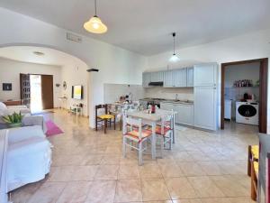 a kitchen and living room with a table and chairs at Ale house experience in Riola Sardo