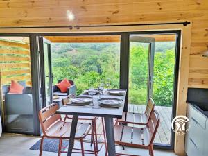 a dining room with a table and chairs on a balcony at Chalet 24 La Forêt, Camping de Coupeau, 4 personnes in Saint-Berthevin