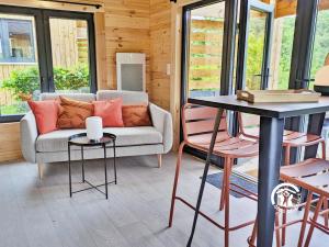 a living room with a couch and a table at Chalet 24 La Forêt, Camping de Coupeau, 4 personnes in Saint-Berthevin +10 photos