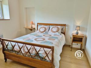 a bedroom with a bed and a table with a lamp at Gîte de Montgiroux, jusqu'à 5-6 personnes in Alexain +44 photos