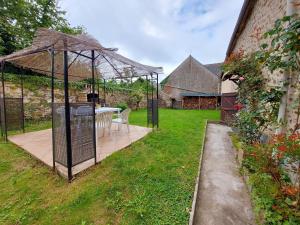 a gazebo with a table and chairs in a yard at Les Bruyères in Neuilly-le-Vendin