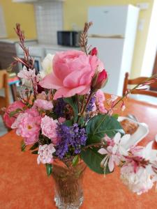 a vase filled with pink and purple flowers on a table at La Boulaie in Saint-Ouen-des-Toits