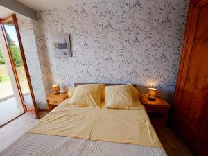 a bedroom with a bed and two lamps on a table at La Boulaie in Saint-Ouen-des-Toits