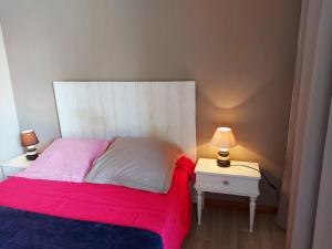 a bedroom with a bed and a nightstand with two lamps at La Boulaie in Saint-Ouen-des-Toits +14 photos