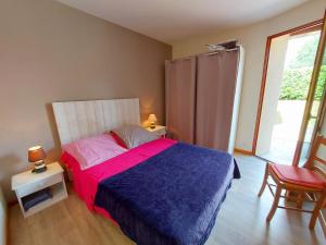 a bedroom with a bed with a blue and pink blanket at La Boulaie in Saint-Ouen-des-Toits +12 photos