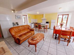 a living room with a leather couch and a table at La Boulaie in Saint-Ouen-des-Toits