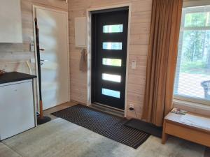 a black door in a room with a window at Modern holiday cabin in Saimaa in Enonkoski