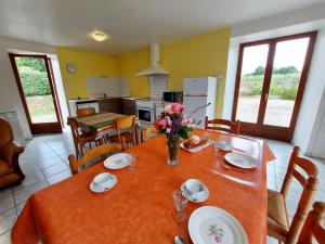 a kitchen with a table with a vase of flowers on it at La Boulaie in Saint-Ouen-des-Toits