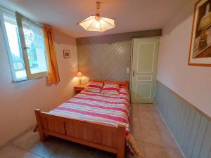 a small bedroom with a bed and a window at Les Iris in Saint-Ellier-du-Maine