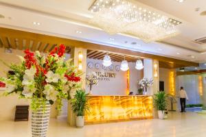 a lobby with vases filled with flowers in a building at Tu Son Luxury Hotel in Bắc Ninh