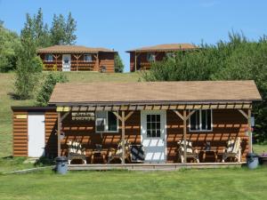 a log cabin with a porch and chairs in front at Orchard View Bed and Breakfast in Moose Jaw