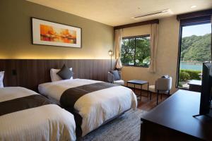 a hotel room with two beds and a television at TAOYA Nachikatsuura in Nachikatsuura