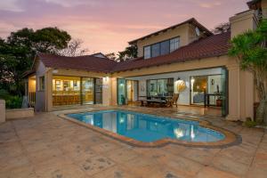 una piscina frente a una casa en Eagle Road Holiday Home, en Umtentweni