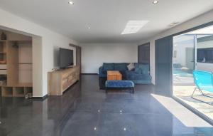 Una sala de estar con un sofá azul y un televisor. en Amazing Home In Nissan-Lez-Enserune With Wifi, en Nissan-lez-Enserune