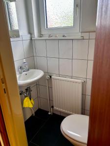 ein Badezimmer mit Waschbecken und Toilette und einem Fenster in der Unterkunft Ferienhaus Müller in Soltau