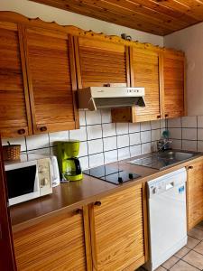 eine Küche mit Holzschränken und einer weißen Mikrowelle in der Unterkunft Ferienhaus Müller in Soltau + 16 Fotos