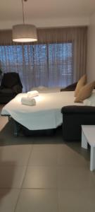 a bedroom with a large bed and a couch at Praia da Rocha- PORTIMÃO Apartamento T1 in Praia da Rocha +15 photos
