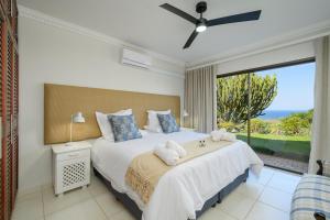 Un dormitorio con una cama grande con una ventana grande. en Eagle Road Holiday Home, en Umtentweni 18 fotos más