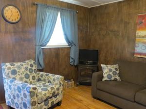 a living room with a couch and a chair and a window at Orchard View Bed and Breakfast in Moose Jaw