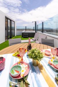 a table with plates of food and a bottle of wine at Apartamento moderno con jacuzzi y vista mar in Cotillo