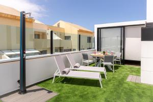a balcony with a hammock and a table and chairs at Apartamento moderno con jacuzzi y vista mar in Cotillo
