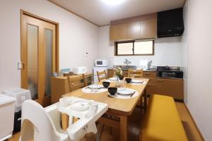 a kitchen with a table and chairs in a room at Guesthouse KEN in Toyama