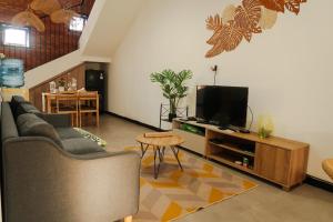 a living room with a couch and a tv at Terrace Hills Villa Malang in Karangploso