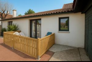 a wooden deck with chairs on a house at Cottage les Écuries du faubourg in Béthune