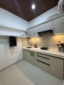 a kitchen with white cabinets and a counter top at House of Kashi Homestay- Studio and Budget Rooms in Kashi