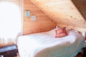 a bedroom with a bed in a wooden cabin at Cozy Wooden House with Fireplace near Zabljak & Durmitor in Žabljak