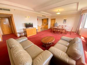 a living room with a couch and a table at Parkview Hotel in Kampong Jerudong