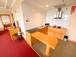 a kitchen with a wooden table in a room at Parkview Hotel in Kampong Jerudong