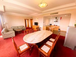 a living room with a table and chairs and a couch at Parkview Hotel in Kampong Jerudong