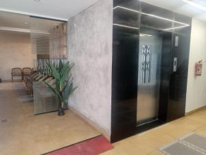 a lobby with a black elevator and a potted plant at Hotel La Premier in Hyderabad