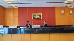 zwei Frauen sitzen an einem Tresen in einem Wartezimmer in der Unterkunft Diamond Plaza Hotel in Surat Thani