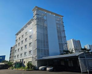 a tall building with cars parked in front of it at Yeoju Hightel in Yeoju