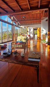 a living room with a bed and a wooden table at Casa Miralago in Santana do Riacho